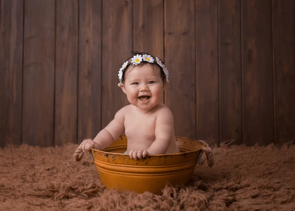 This image is of bubbly baby Lola-Kate! Lola-Kate came into the studio for a 6 month session. The image was taken using natural light in my home-based studio, and the rustic bucket and cute little daisy headband give a fun pop to the image. Lola-Kate was such a happy baby, showing off her smiles and giggling throughout the session.