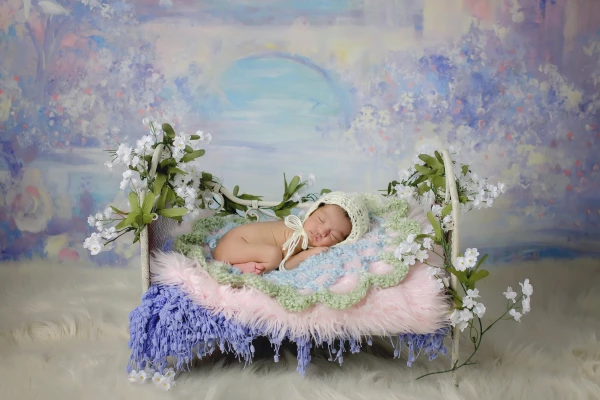 Baby girl is the smallest baby I have photographed to date over the years at 5lbs and this is one of my favorite portraits to date.  Sweet girl is in a simple knit bonnet with a purple princess flower set up and vintage ivory bed.   