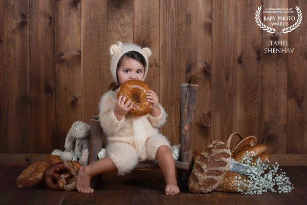 BREAD.  As I organized the studio to take some pictures on this set, I went to the bakery and collected all the goodies: bread, pretzels, and baguettes, that will decorate the set and make the little one enjoy eating anything she wants.  I was driving to the studio surrounded by the smell of a bakery.  The little one enjoyed the fresh bread and I really enjoyed capturing those sweet moments of new tastings of different pieces of bread.  This picture was taken right at the beginning of the shoot, but that sweet look just melted my heart.