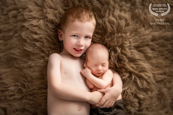 This picture was taken with natural light. I really love how the soft light hits the skin of the two brothers. It was not easy to take this picture because the baby was not wrapped but the parents loved the skin on skin look. Very happy with the result.