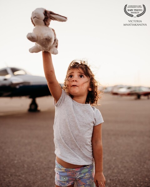 This was taken at the local airport . Her first time seeing the planes this close. And I just love the expression on her face , as the plane takes off , the sound of it , the grand size ,  the fear,  it is all expressed in this little face .  First wonder .