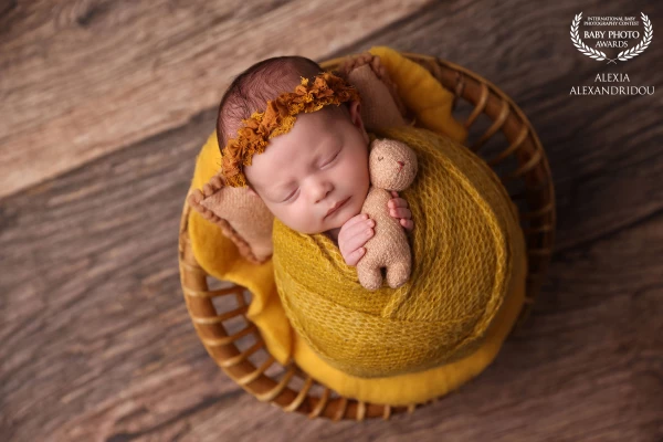 Wrapped in sunshine and dreams, holding tight to the tiniest teddy — a little bundle of calm in a golden world.