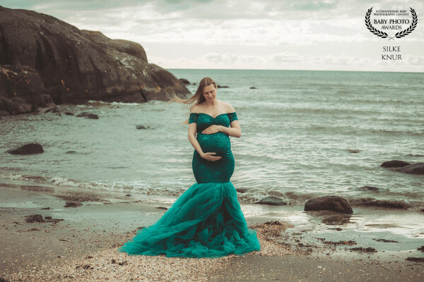 A stormy , cloudy day  at the sea and in the middle this beautyful pregnant  woman. It makes a kind...