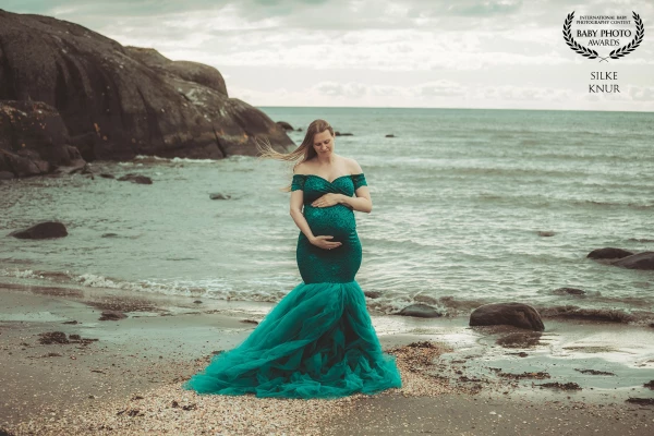A stormy , cloudy day  at the sea and in the middle this beautyful pregnant  woman. It makes a kind...