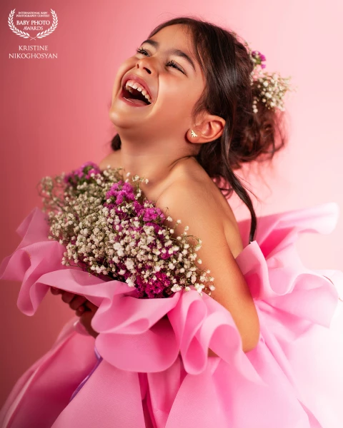 Pure joy captured in a single moment — a child’s laughter wrapped in softness, light, and color.