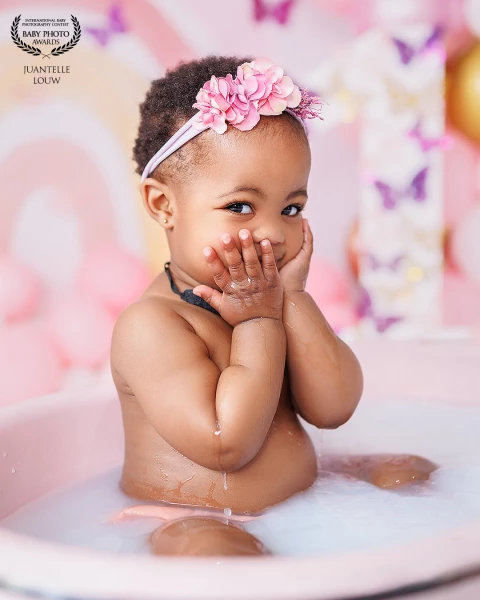 Adorable baby girl in milk bath