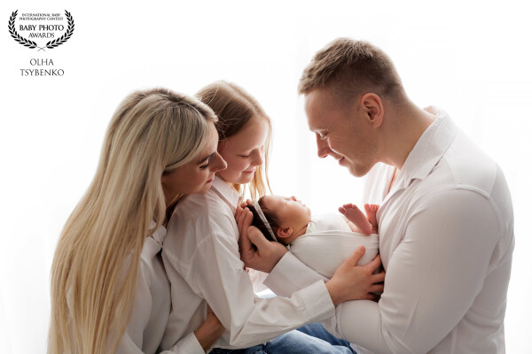Wrapped in light and tenderness, this image tells the story of a family transformed by new life. In...