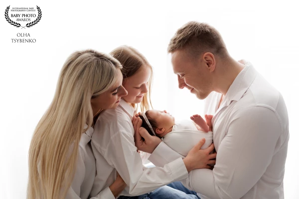 Wrapped in light and tenderness, this image tells the story of a family transformed by new life. In...