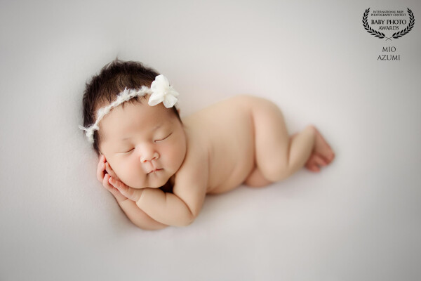 A classic newborn pose, nestled with tiny hands resting gently against their cheek. I wonder what be...