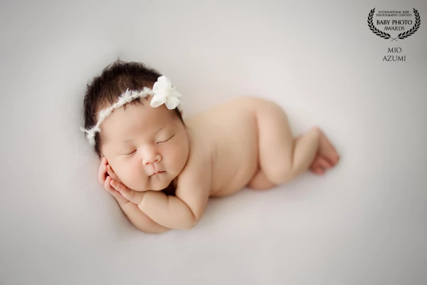 A classic newborn pose, nestled with tiny hands resting gently against their cheek. I wonder what be...