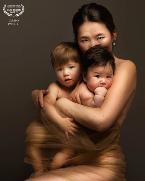 A mother hugging her two children, enveloping in warmth and love. It's a powerful reminder of the bonds we create between us and the people we love.