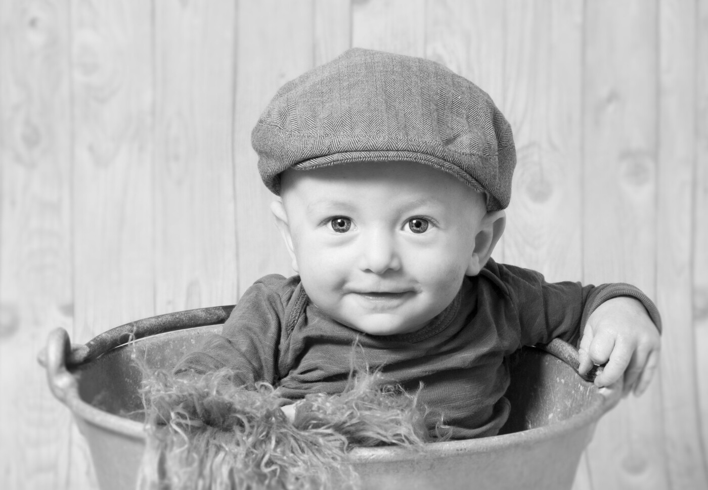 The image is of baby Tjalfe age 4 months. After struggling with kolik since birth this is one of the first pictures of him smiling. Tjalfe is sitting in a vintage milk bucket from the fifties.