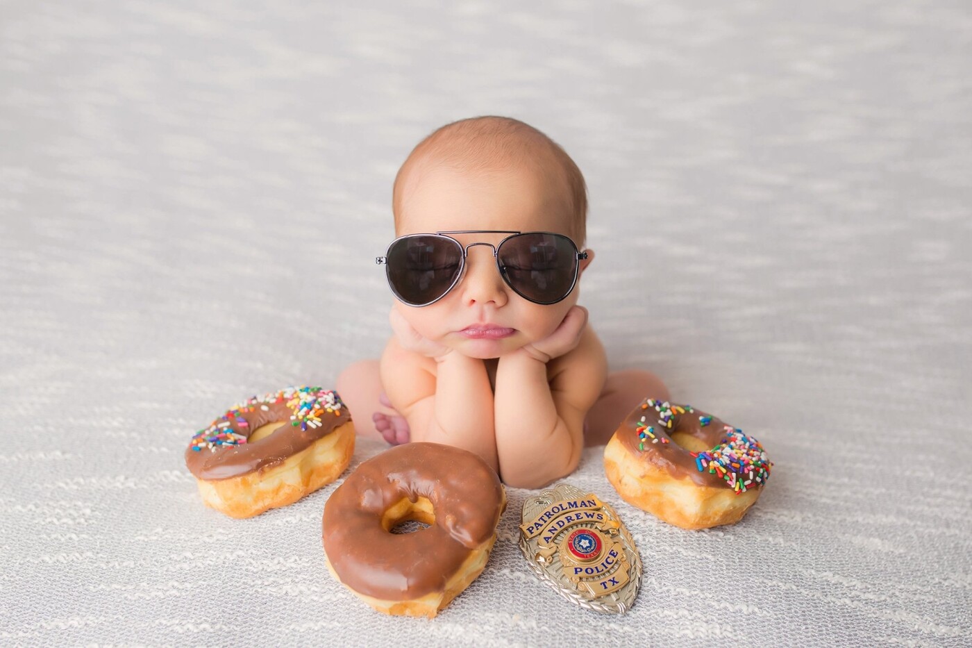 Mason's mommy told me prior to her session she would like to include donuts, and some of  her husband's police uniform into his newborn session. Right away I had this image pop into my head! It turned out just like I imagined.