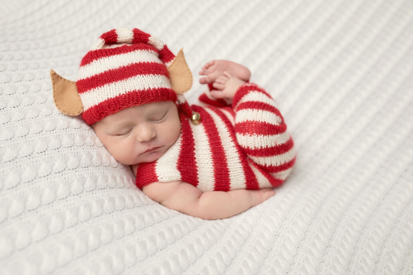 This sweet little elf was just 10 days old at her newborn photo shoot.  She broke a two month long streak of newborn boys in the studio so we had a little extra fun with props and colors during her session.  With Christmas just a few weeks away, mom fell in love with this set up too.