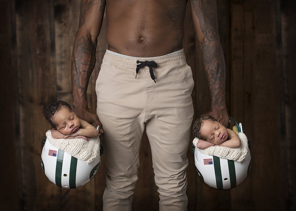 NFL's Antonio Cromartie with his twins Jynx and J'adore.  This image was the Cromartie Family's public reveal by US Weekly. Antonio brought all of his NFL helmets and asked me to use them.  Um, YES!!!  So honored to have been asked to capture this very important moment for Terricka and Antonio.    jacquelinebellefleur.com 