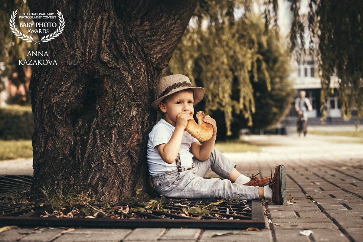 For some reason, small children like to eat not too useful foods like carrots or cabbages, but pasta or bread. My son is no different from other children. In this photo I showed my son a good breakfast in the park.