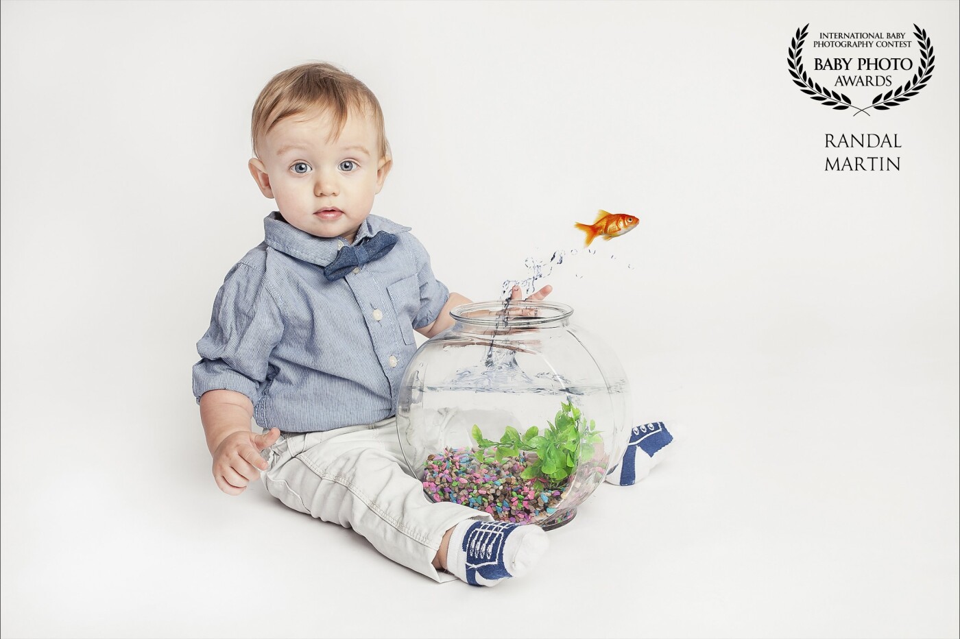 Photo was taken for his 1 year birthday. The family loves fishing and so they wanted to incorporate a fish in the photo. Knowing how hard it is to try and find a trained gold fish, I decided to photoshop one in for the family. His reaction is just perfect for the shot. 