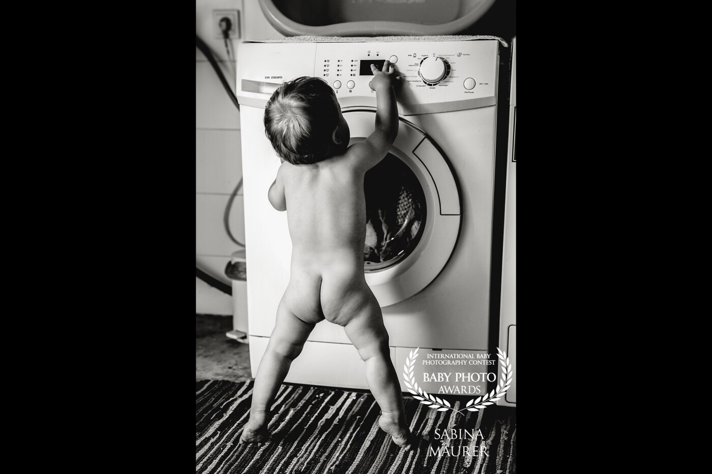 This young man is 13 months old and wants to help his mummy with the laundry. The moment when he reached for the buttons was just perfect for a snapshot.