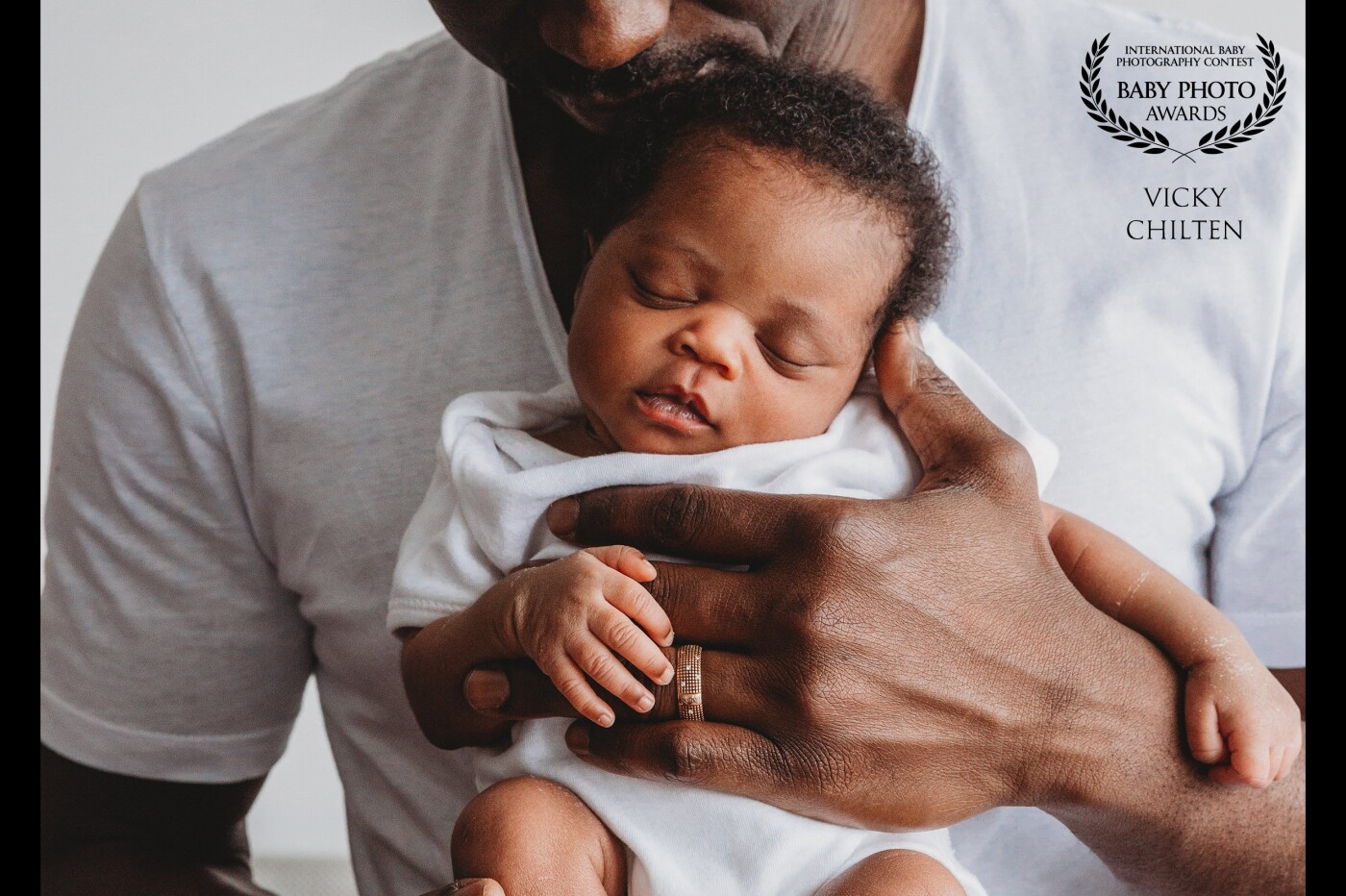 Daddy was holding his newborn daughter with such ease and love, I just had them turn slightly towards the window and there it was, such a special moment to capture! Sometimes things just fall into place perfectly. <br />
This is from a lifestyle in-home newborn session, my favourite.