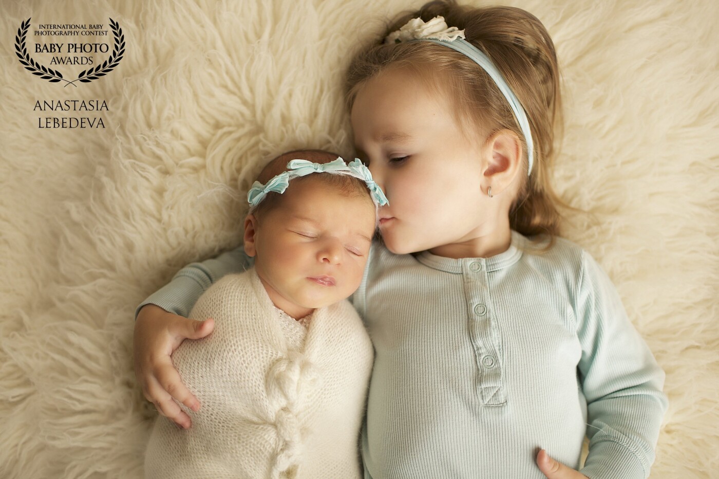 Look at this touching photo, where the older sister gently hugs and cuddles her newborn younger sister. The very love and tenderness in this frame.