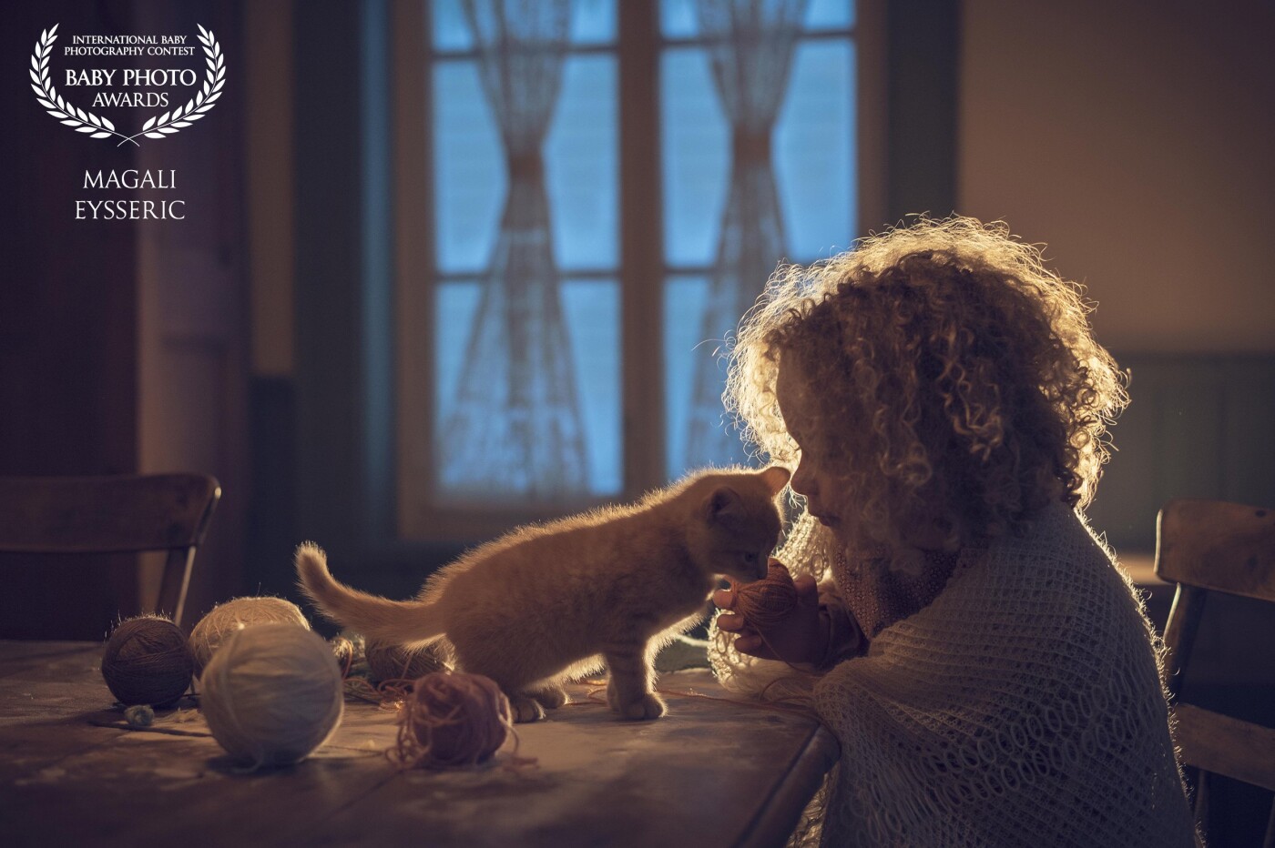 At the blue hours, she's playing with her cat <br />
This little girl was so pretty with her blond curly hair<br />
She was playing for the camera.<br />
