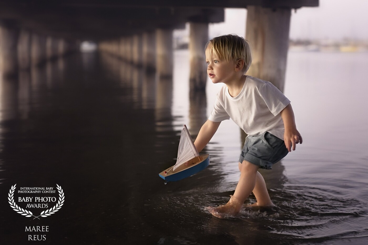 This little boy loves all things boating as his father sails yachts. This photo was taken just after sunset, under a pier in Melbourne, I just love the focus in his eyes as he sails off into the sunset.