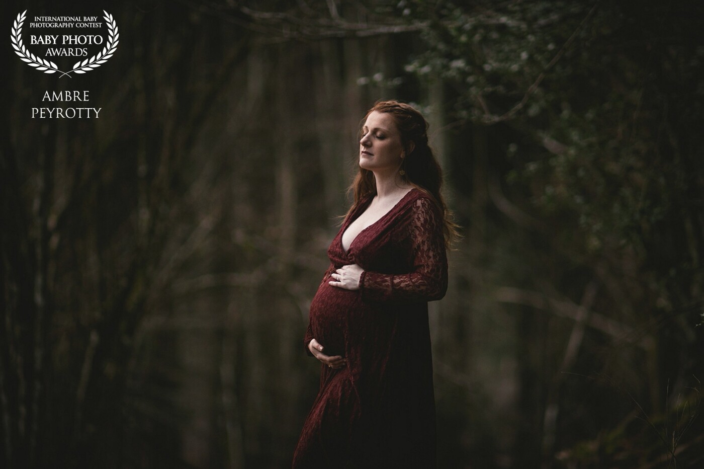 Aurore is a beautiful mom and has amazing red hair. I wanted to emphasize that while creating something truly special in the forest, so we chose this very dark and green forest as she wore a beautiful red dress.
