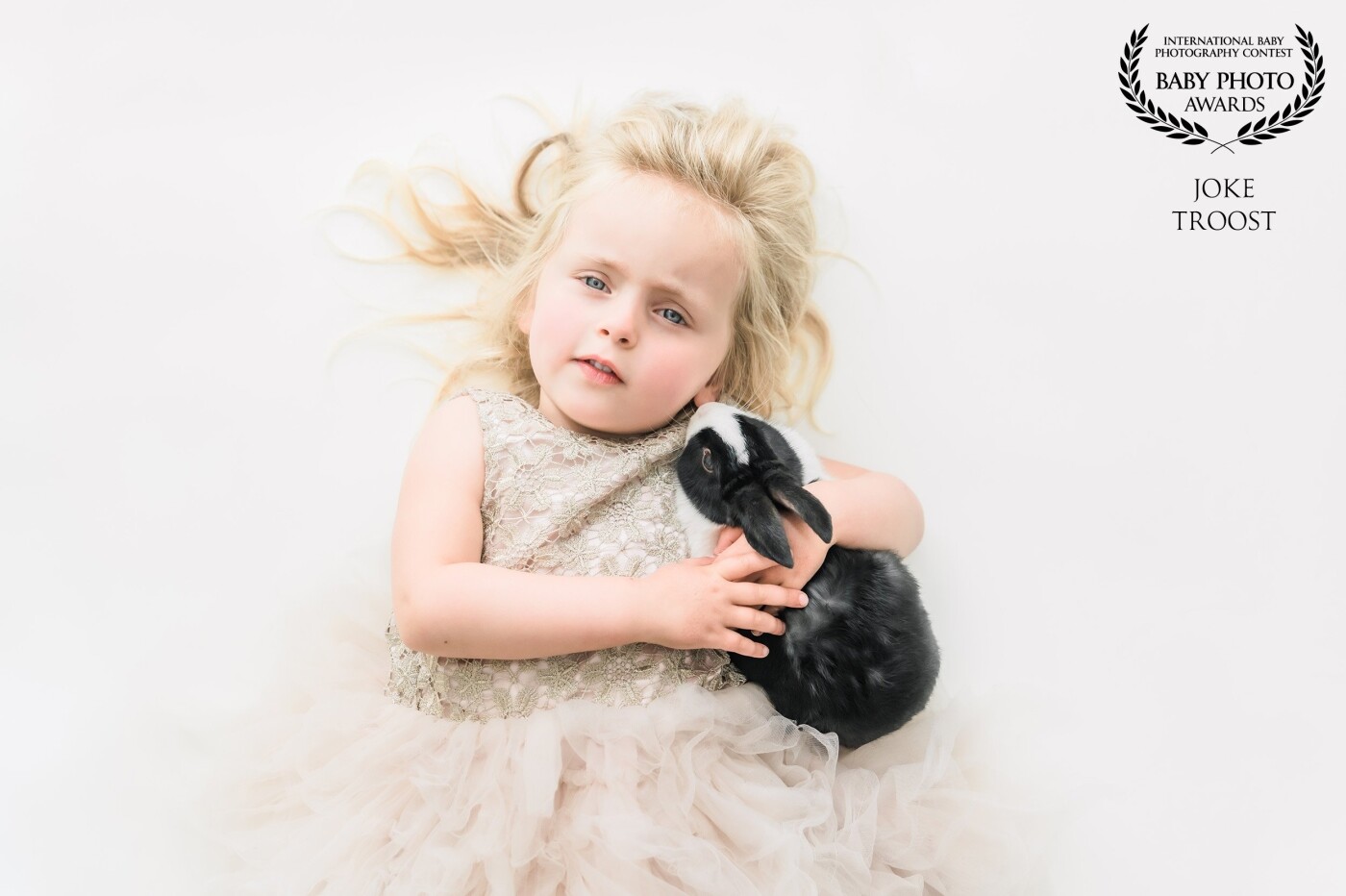 This sweet little girl is my own little girl called Benthe (3 years old) and her rabbit called Pretzel. Benthe loves to be my model and with her beautiful blue eyes and curious looks, it is always a pleasure to photograph her. I'm particularly happy that this picture was chosen because it is clean, simple, and light.