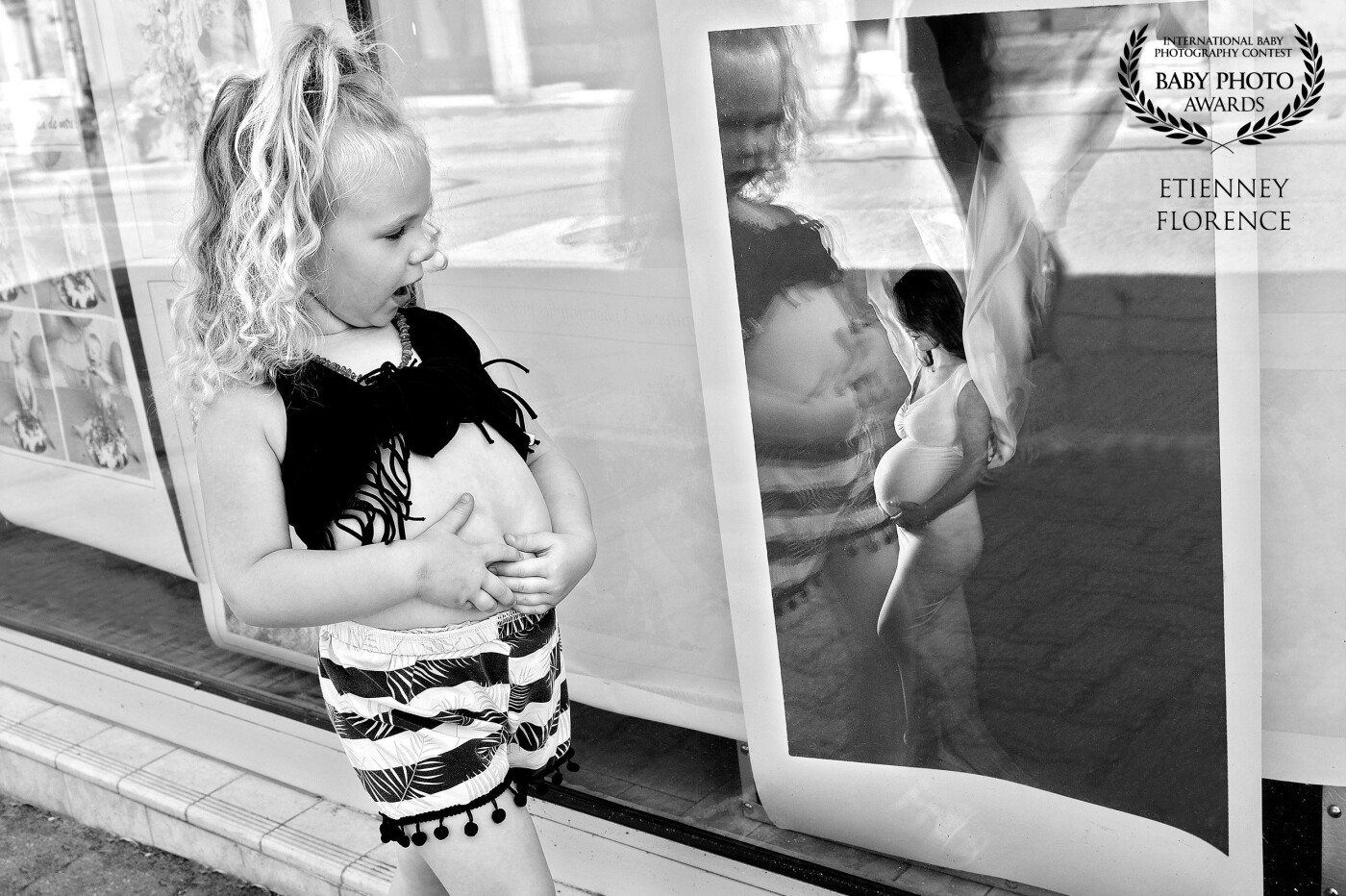 This little girl was attempting to replicate the pose of the pregnant woman on display in the window of my photography studio while I was busy photographing her little brother. I saw her through the window and rushed to shoot her.