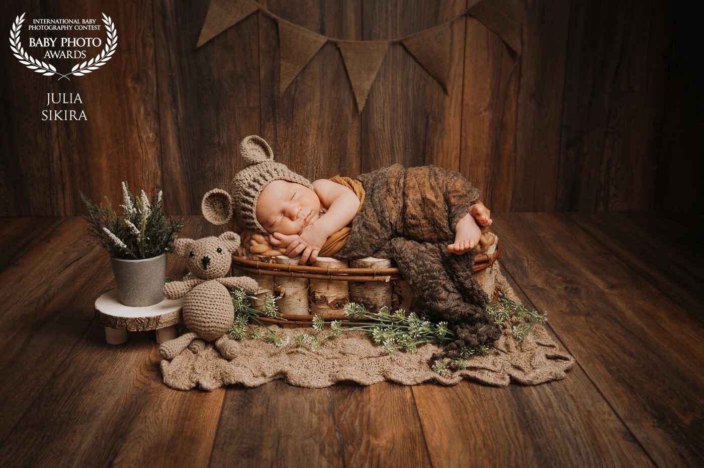 This photo shows a little boy dressed as a bear. The little boy didn't want to take part in the photoshoot and just cried. When I swaddled the baby, he immediately calmed down. Then he also fell asleep. For the photoshoot, we have used natural colors like brown and green. 