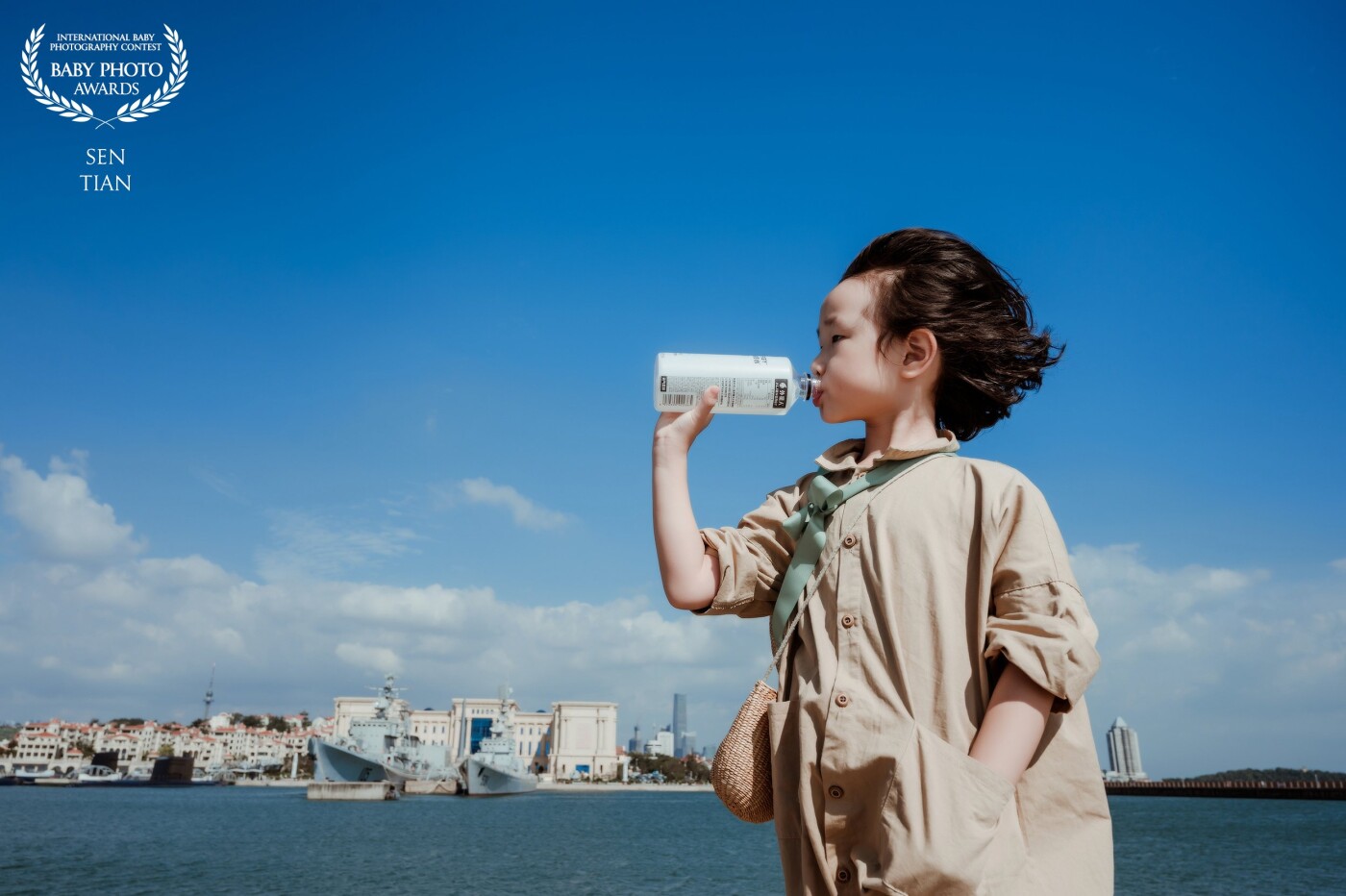 Drink in the wind. In summer, we came to the island. The child ran happily along the dam. When she was tired, she came back for water. The gentle sea breeze blew her hair that day, which was very comfortable. We caught the moment.