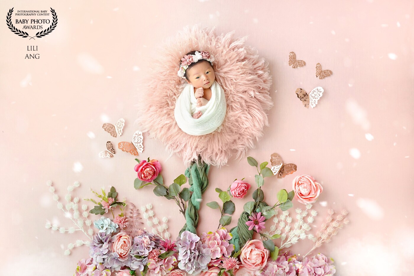 Flowers are girl's best friend.<br />
This picture show the baby as the main flower, and the butterflies know she is the beautiful one.<br />
so they are flying around her :)