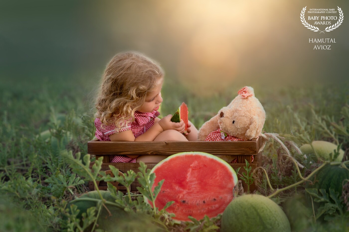 Yaara and her teddy bear in matching dress, sharing watermelon. cannot tell what is sweeter, the watermelon or the two of them :)