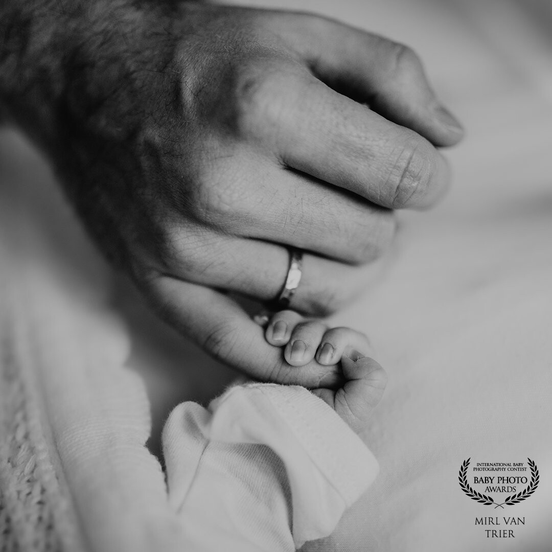 The bond between a father and his son...! <br />
This picture was taken during a newborn session. The little boy wasn't eager to fall asleep, so i asked dad to hold his hands to calm the baby down. In the meanwhile i took this picture and still think that it speaks a thousand words.