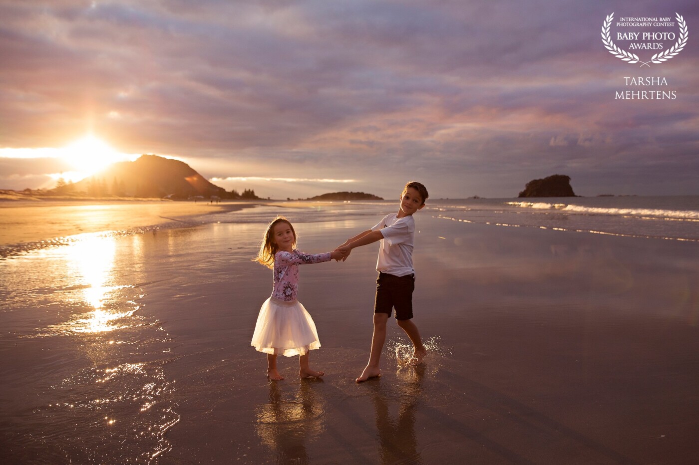 An amazing sunset at Mount Maunganui Beach, New Zealand made for a beautiful image of this brother and sister enjoying the last rays of the day.