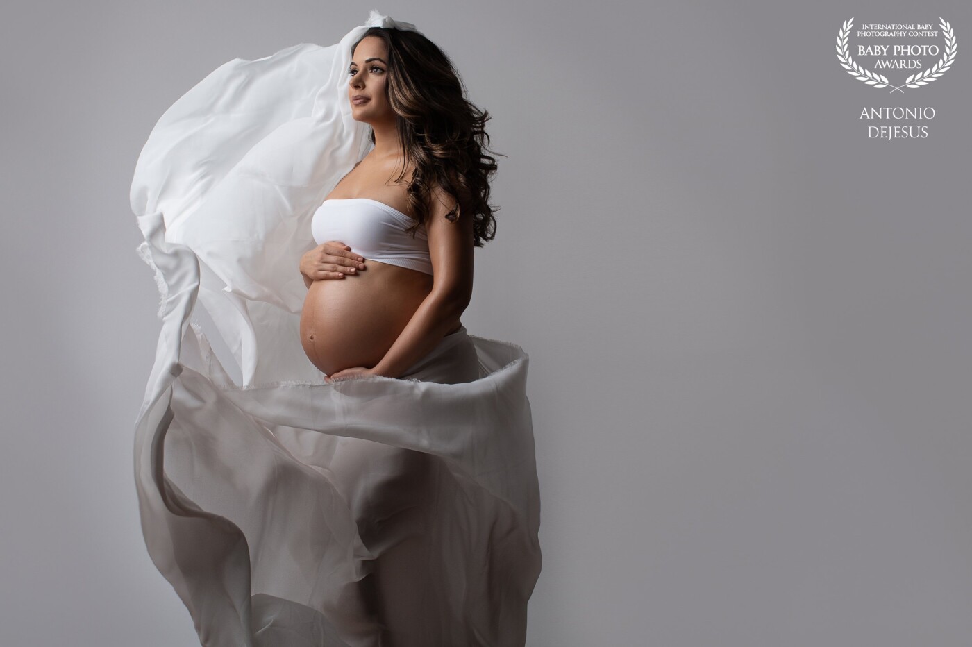 This beautiful mother is expecting her first baby boy! The white flowy silk drape signifies the peaceful and tender and nature of a mother’s love.