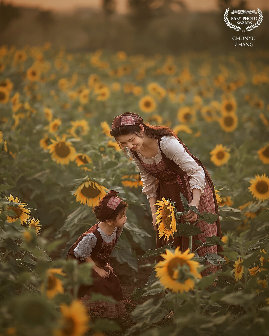 Mom and her little girl played together in sunflower field.The mother took a sunflower flower and said to the baby, this will grow into delicious nuts in the future, do you know what it is?