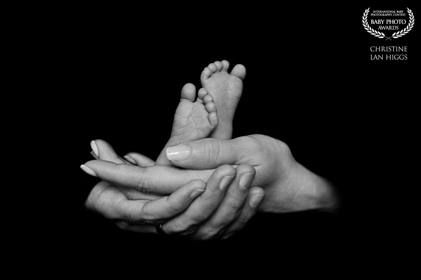 This is the parents first child and it’s a girl! The hands of the parents lovingly embrace each other and show off the dainty feet of their precious baby.