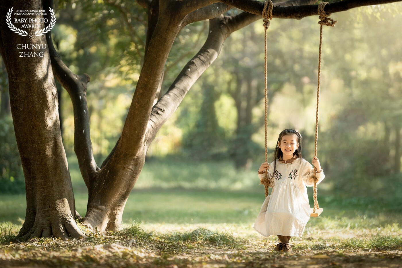 Today a cute little girl came under the big tree, she was swinging, the autumn sun was shining warmly on her, the picture was really beautiful