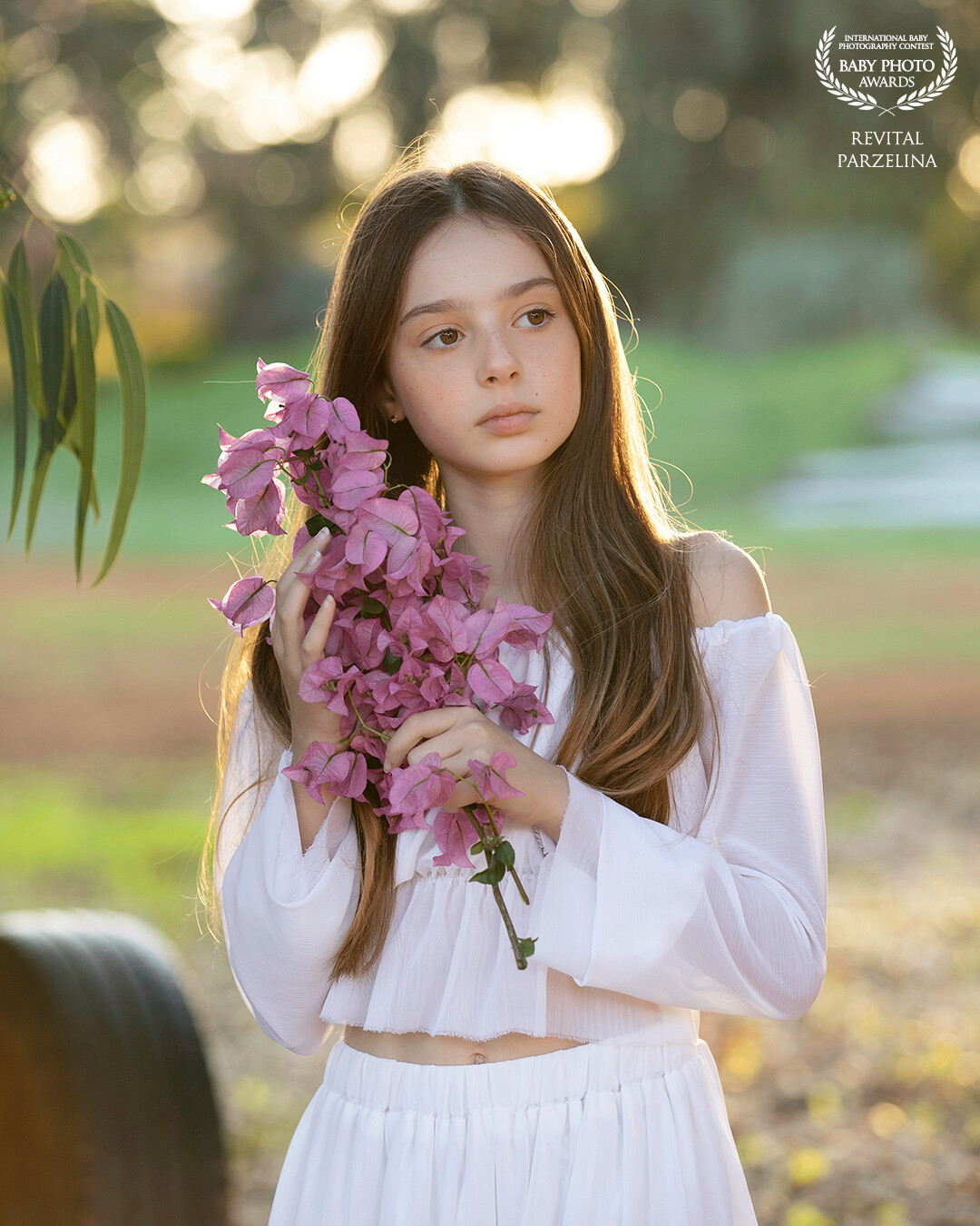 The composition of the image captures the harmony between Raz and the natural world. The soft focus creates a dreamy ambiance, while the vibrant colors of the park's flora add a touch of enchantment to the scene. "Innocence Unveiled" is a celebration of youth, curiosity, and the magic of the everyday world seen through the eyes of a child.
