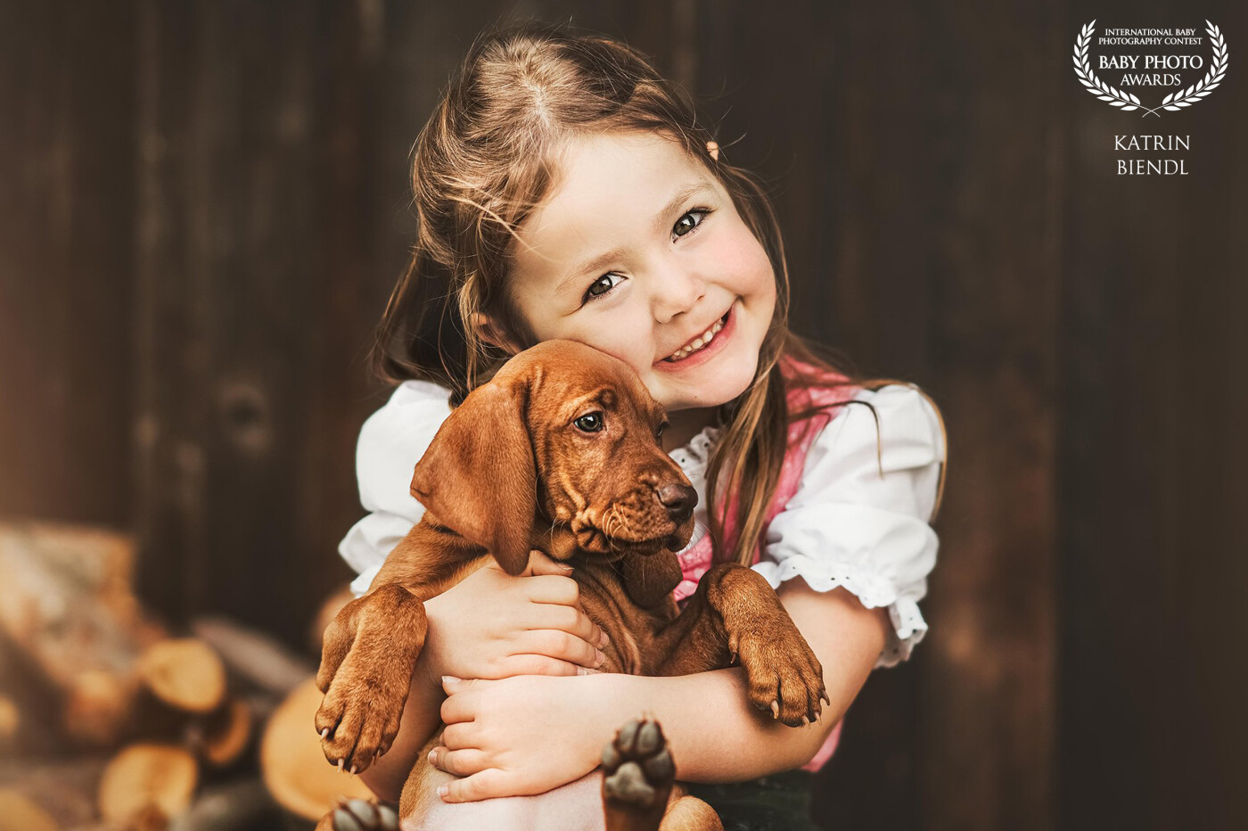 In Bavaria we have a traditional costume which is called "Dirndl". This little girl wear such a Dirndl. I think she have a cute smiley and loves her puppy a lot.