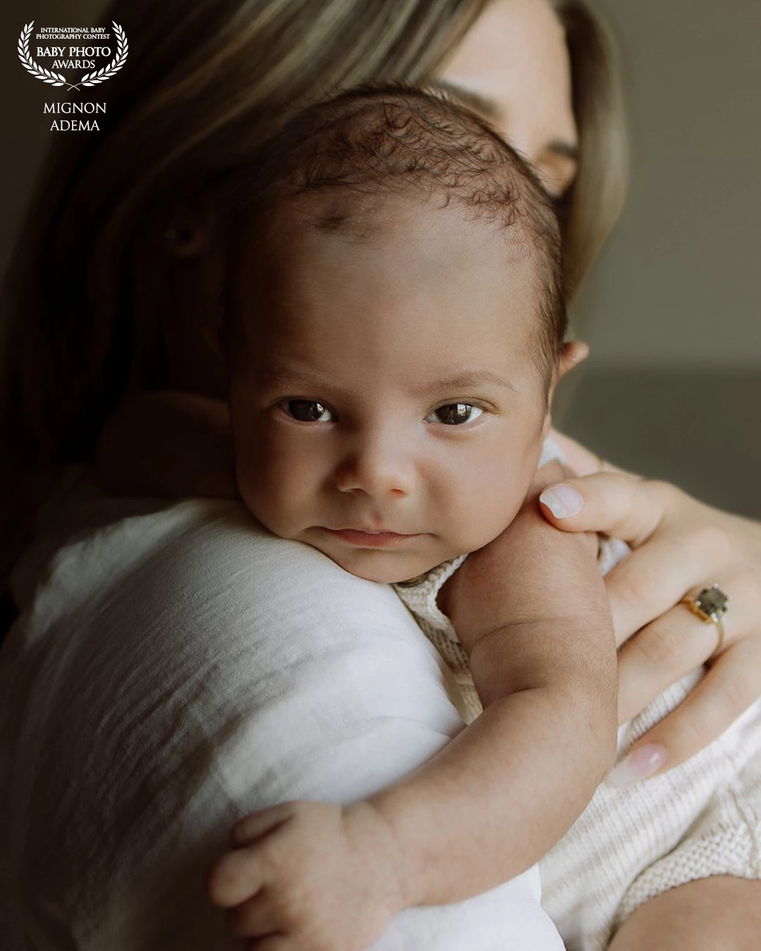 There’s something so powerful in the calm of this moment. A baby resting gently on their mother’s shoulder, eyes full of curiosity, skin still soft and new. The warmth of touch, the silent bond. This image captures the quiet magic of early motherhood.<br />
<br />
- Mignon Adema @heymamafotografie