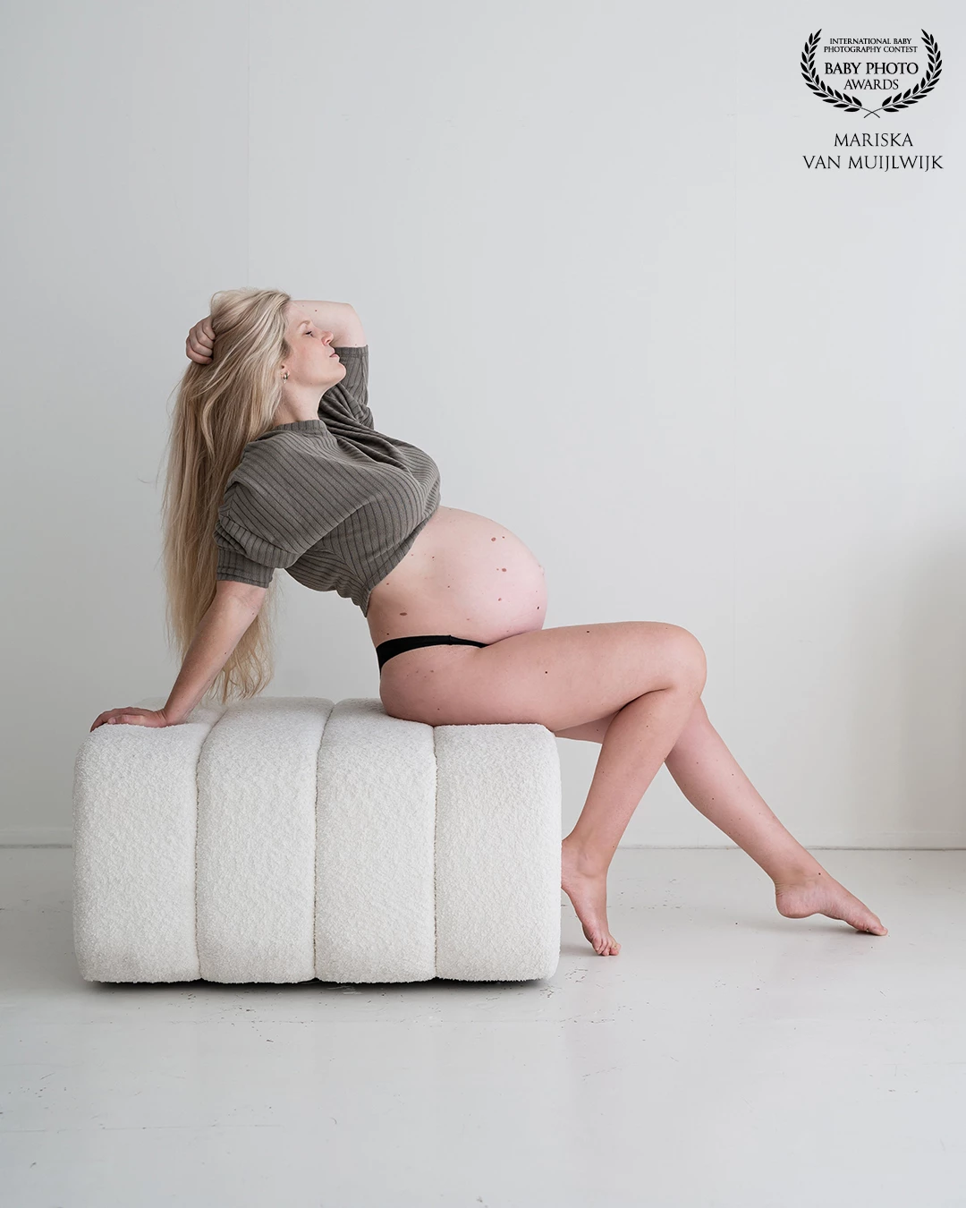 A serene and powerful portrait that captures the raw beauty of pregnancy. The pose radiates confidence and softness, celebrating the strength of a woman's body as it nurtures new life. A quiet yet striking tribute to motherhood.