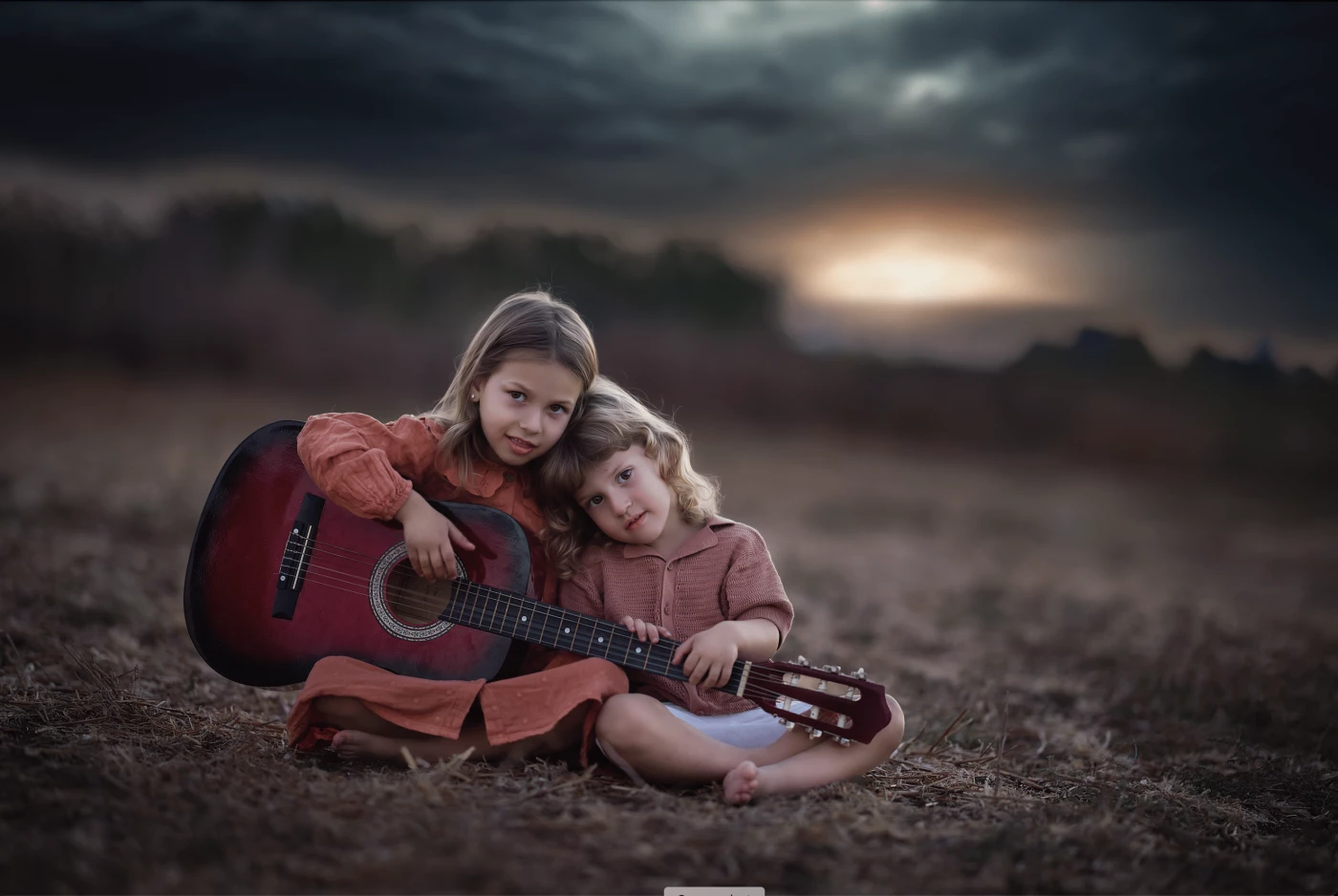 As darkness settles over the quiet landscape, a brother and sister sit side by side, sharing a singl...