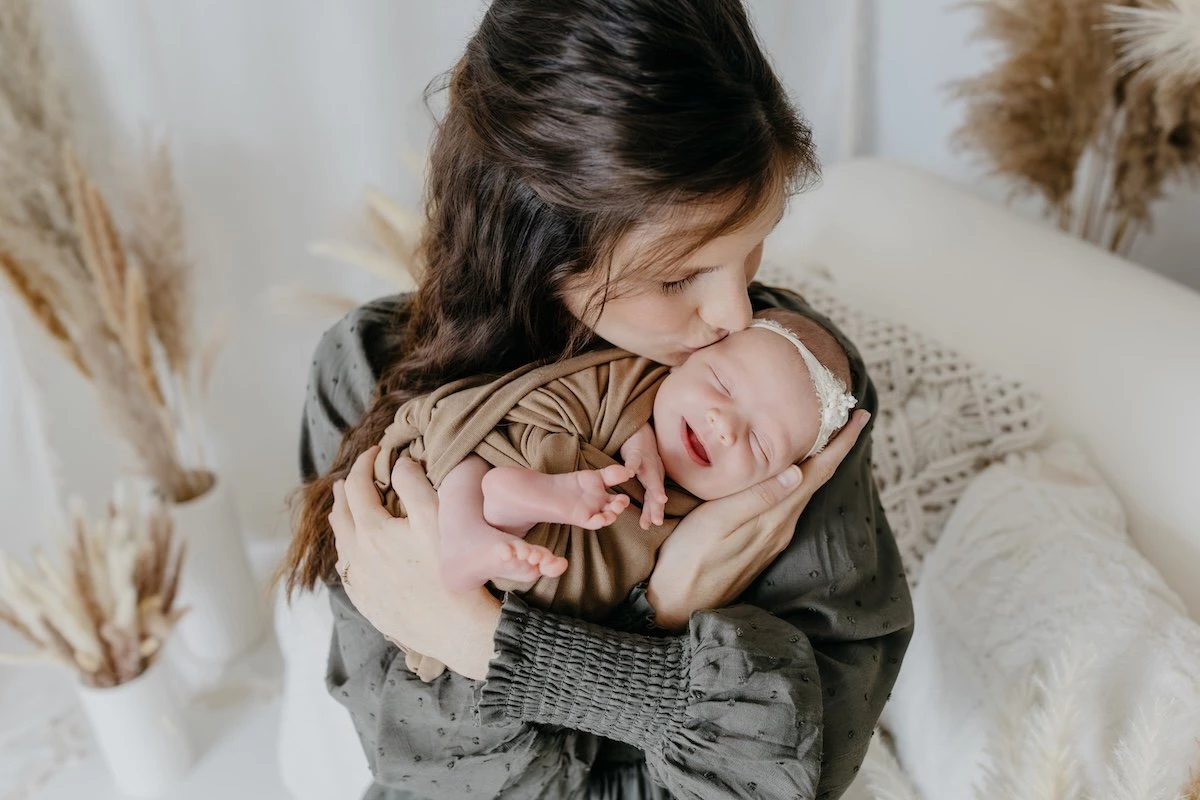 A mother’s kiss and a newborn’s first smile — a fleeting moment of pure connection.
