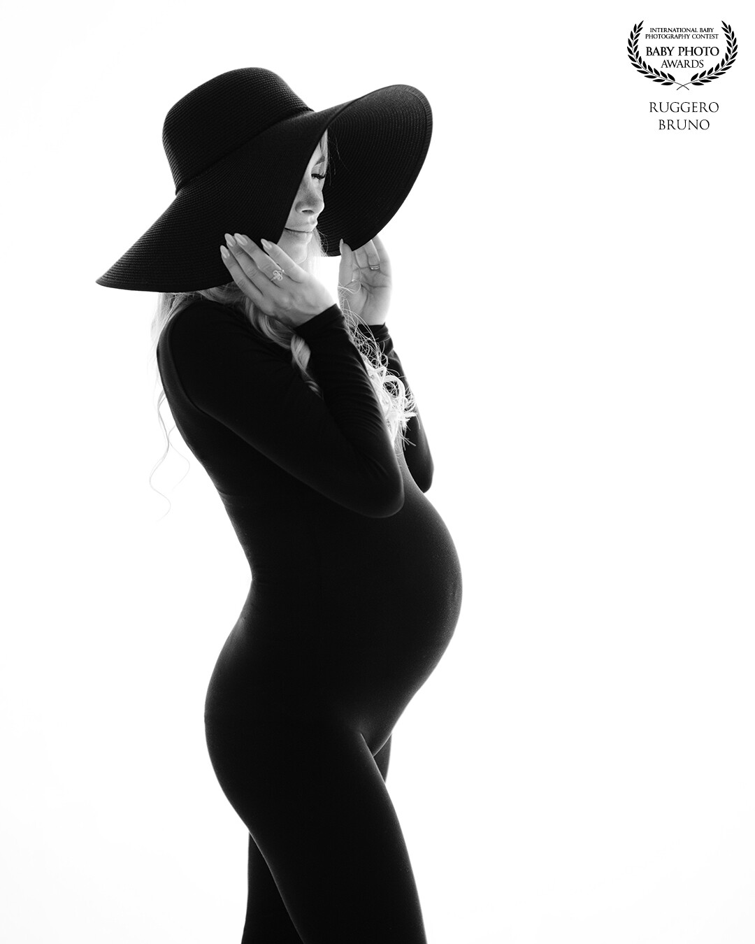 Lines of intimacy<br />
<br />
The backlight of black on white outlines the harmony and beauty of the pregnant woman's body, the large hat encapsulates in similar lines the intimacy of the exclusive emotions felt by the pregnant woman.