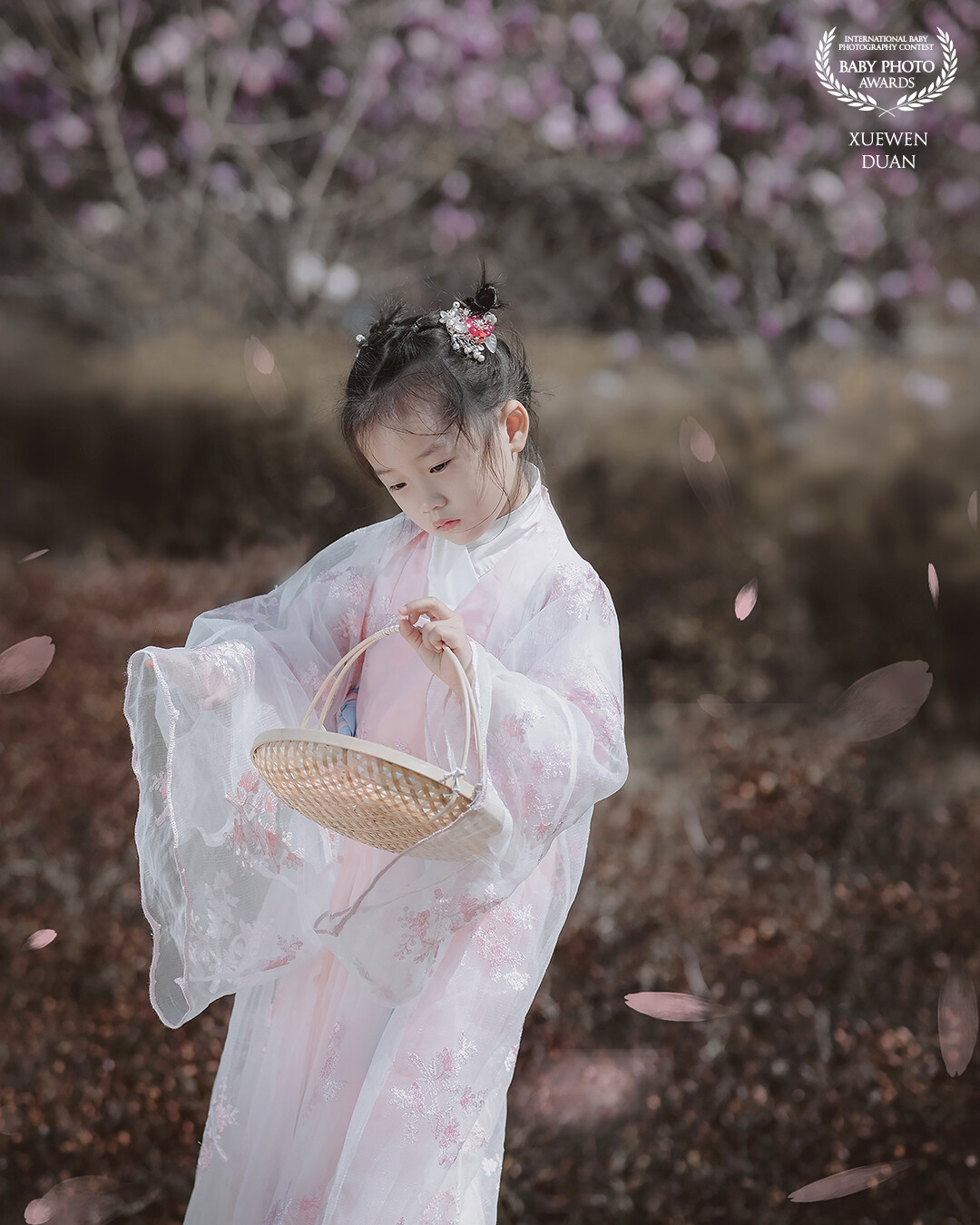 At the moment when the cherry blossoms were falling, the cute little stood under the tree. She turned back and looked like thinking about something. At that moment, she was beautiful!