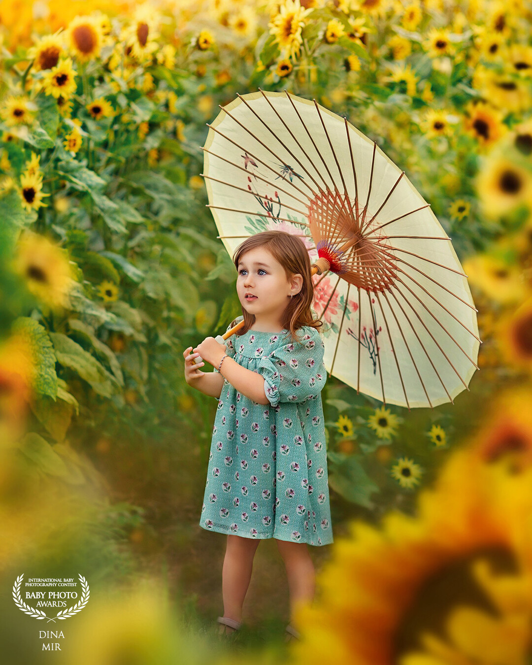Childhood should be bright and beautiful. Olivia hides under an umbrella from the hot summer of 2022